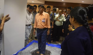 Participants walking barefoot over broken glass